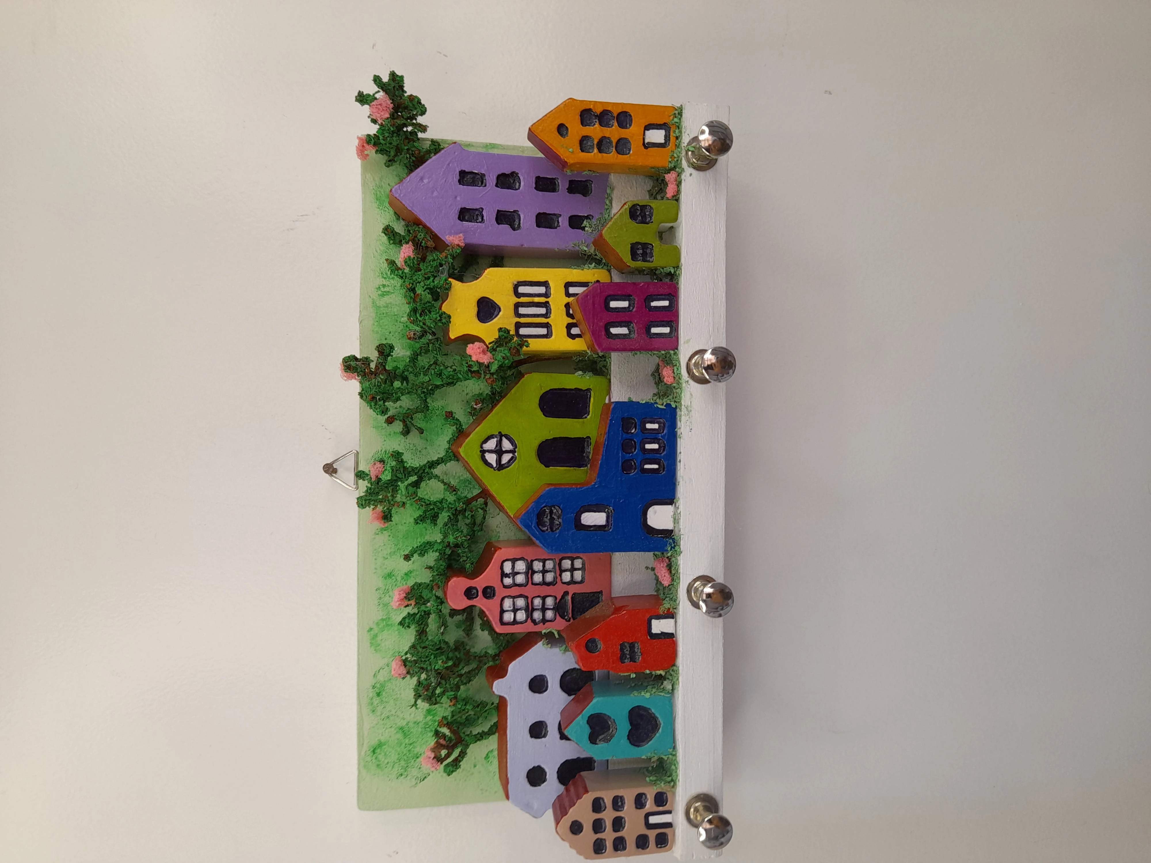 Porta chave de madeira decorado com mini prédios verde